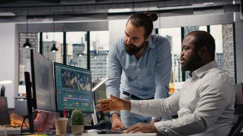 Videographers editing video footage on computer in creative agency Stock Photos