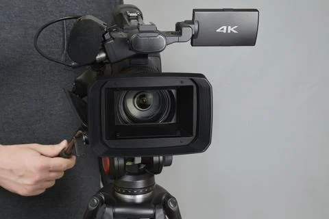 The videographer's hands bring the camera into focus, the cameraman's work in Stock Photos