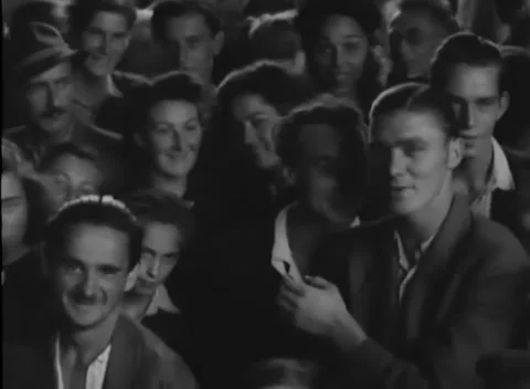 VIENNA, AUSTRIA - 1945: Crowd faces - Hats and caps in a queue outside shutters Stock Footage 344486340