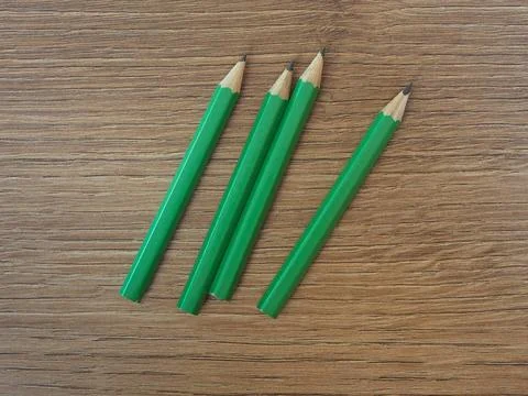Vier grüne Bleistifte auf hölzernem Tischtisch *** four green Pencils at w. Stock Photos
