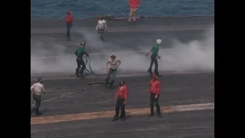 VIetnam 1960s: Flight deck crew members on an aircraft carrier manage equipment Stock Footage 330302227