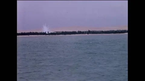 VIETNAM - 1966 - A phosphorus shell explodes along the shoreline, sending up a Stock Footage 316680172