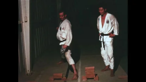 VIETNAM - 1967 - A karate instructor shows a US Marine how to break bricks. Stock Footage 340656014