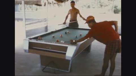 VIETNAM - 1968: Pool Table Match - Two Men Play Pool Under a Beach Shelter Stock Footage 344004876