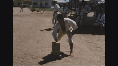 VIETNAM - 1968: Tile Stack Prep - Trainee Steadies a Stack of Flat Tiles Stock Footage 344004985