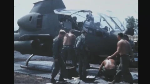 VIETNAM - 1969: Ground crew work around parked Cobra gunship Stock Footage 341737463