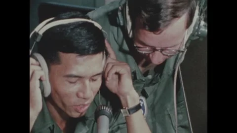 VIETNAM - 1970: Pressed earcups - Trainee presses his headset with both hands 库存影片 344004091