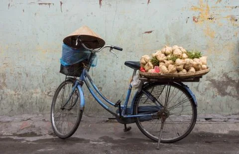 Vietnamese bicycle load with vegetables and conical hat rested on the handlebar. Stock Photos