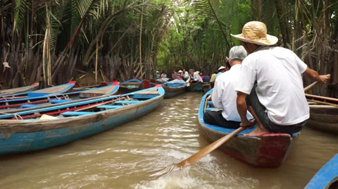 Vietnamese boatman rowing a boat on a congested canal in Mekong delta, Vietnam Stock Footage 37568802