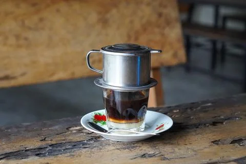 Vietnamese drip coffee made with bold robusta on a wooden table Foto stock
