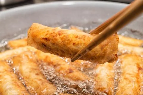 Vietnamese egg rolls, cha gio, deep fried in boiling oil pan Stock Photos