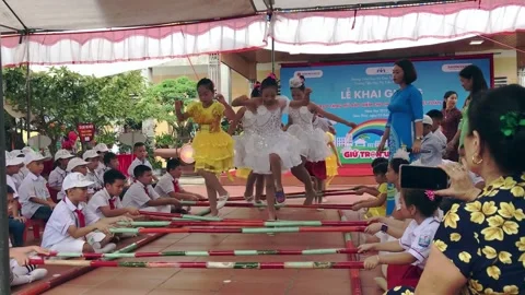 Vietnamese elementary pupils performing bamboo dance with colorful costumes Video stock 142180765