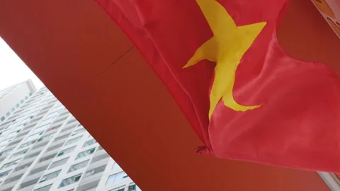 The Vietnamese flag flying in front of a skyscraper. Stock Footage 319536390