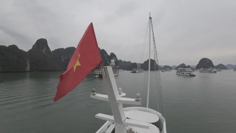 Vietnamese flag flying high slow mo from tourist boat at halong bay Stock Footage 288566827