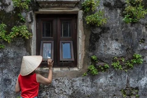 Vietnamese girl look at the olden window ancient building Stock Photos