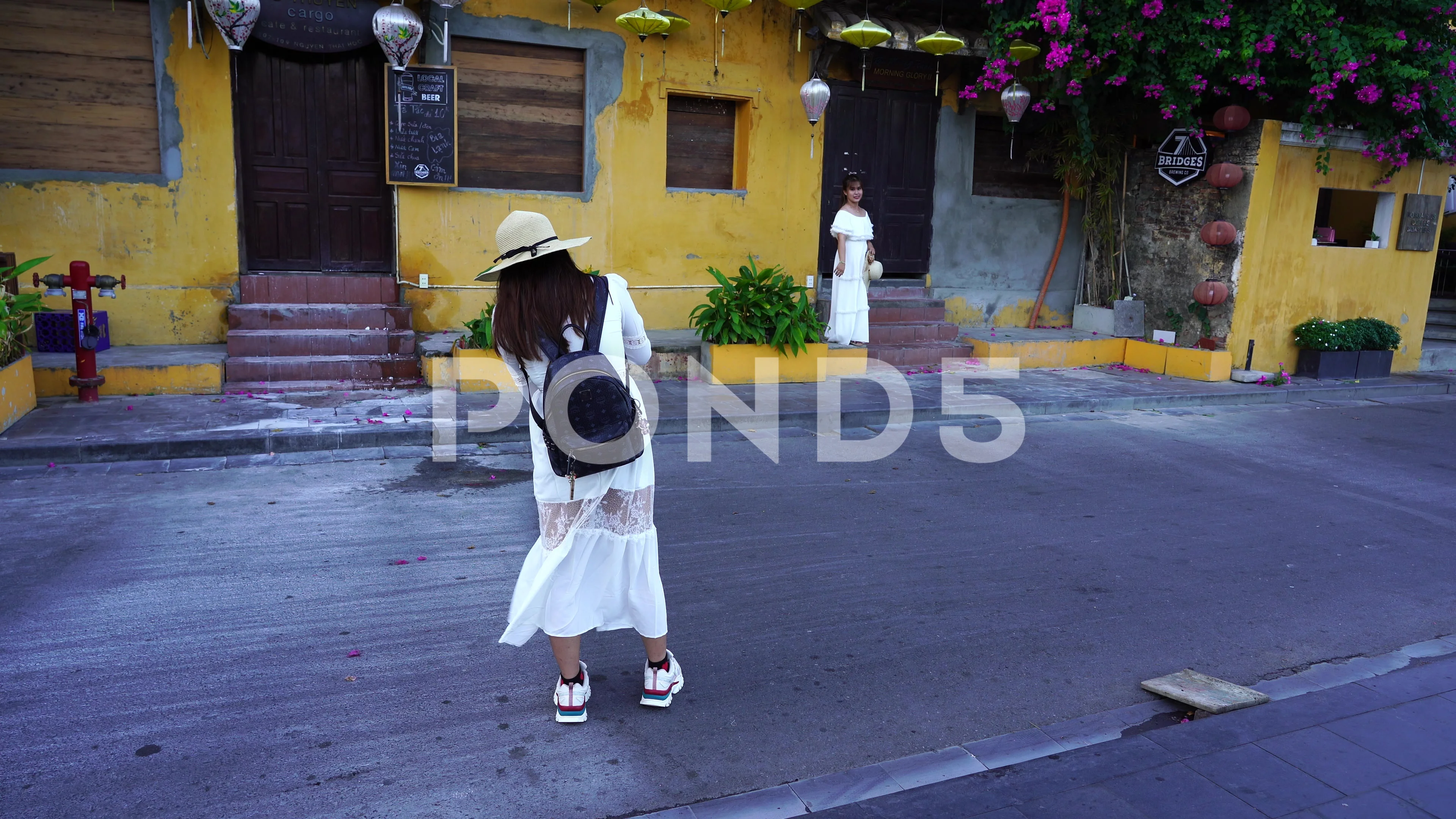 Vietnamese girl taking pictures of their girlfriends in Hoi An, Vietnam