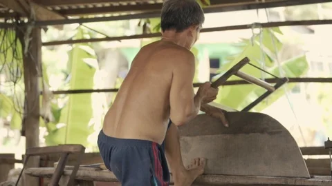 Vietnamese Old Man is doing woodwork with saw 動画素材 107927986