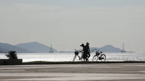Vietnamese people getting ready to ride bikes along beach Stock Footage 18174458