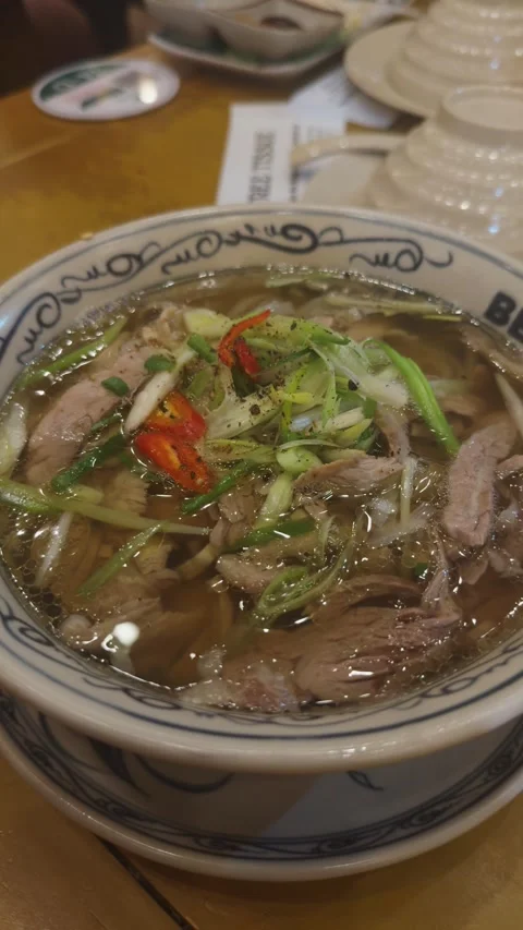 Vietnamese pho beef noodle soup served in a traditional bowl, featuring sliced Stock Footage 345515354