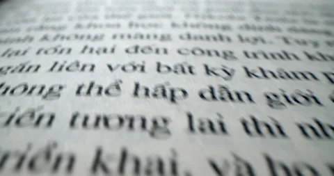 Vietnamese text. Fast moving macro view past inside book.Dolly shot open book Stock Footage 223002948