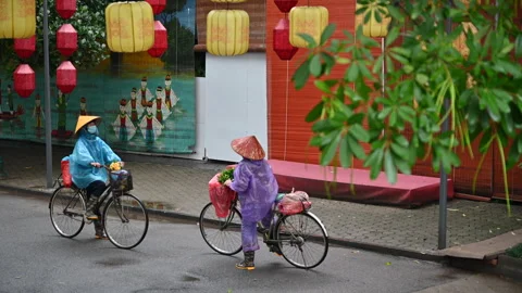 Vietnamese  Workers  in Conical Hats Having a Conversation on Their Bicycles Stock Footage 296548525