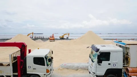 A view of 2 trucks in the construction site of the Manila Bay White Sand project Stock Footage