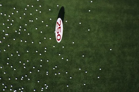 View of 250 yard driving range marker from above with golf balls scattered Fotos Stock