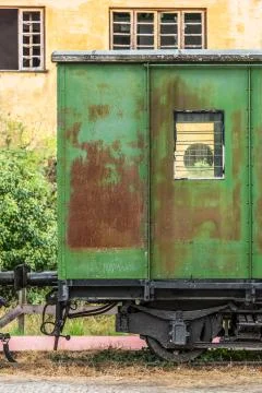 View of a abandoned and older rustic train wagon, yellow building Foto stock