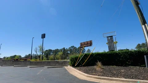 View of a abandoned area blank sign and empty street weeds and parking lot Stock Footage 174413256