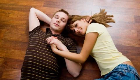 View from above of affectionate couple lying on the floor and looking at camera Fotos Stock