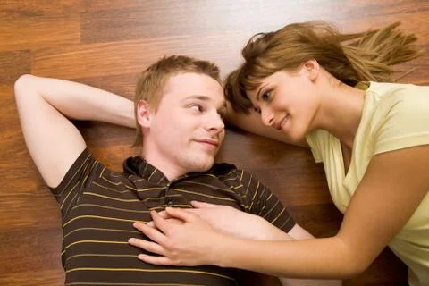 View from above of affectionate couple lying on the floor and looking at each ot Fotos Stock
