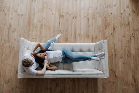 View from above affectionate young multiracial couple cuddling on sofa Stock Photos