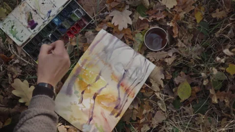 View from above, the artist's hand paints a landscape of an autumn forest in Stock-Footage 337122956