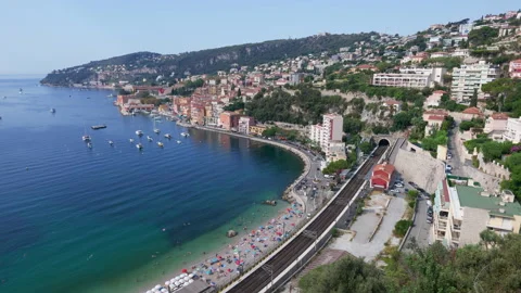 View from above of a beach beside a coastal railway with a colorful hillside Stock Footage 344814146