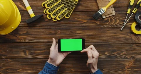 View from above on the black horizontal smartphone on the wooden desk of workman Stock Footage 96183396