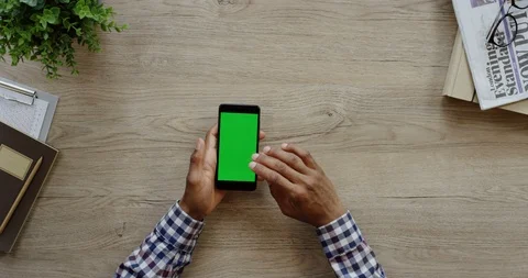View from above on the black smartphone lying vertically on the wooden light Stock Footage 96013260