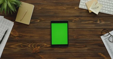 View from above on the black tablet computer with a green screen lying Stock Footage 88418474