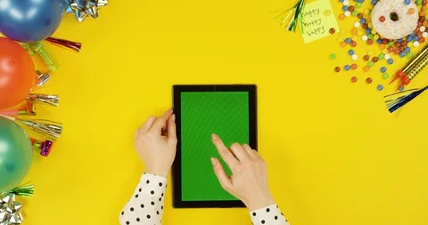 View from above on the black tablet device on the yellow table with happy Video stock 89318819