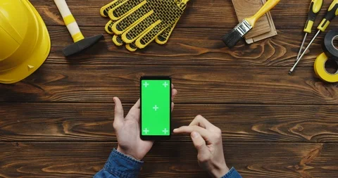 View from above on the black vertical smartphone on the wooden desk of workman Stock Footage 96183036