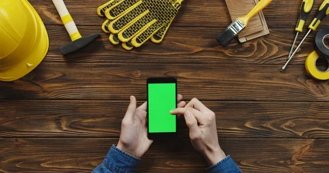 View from above on the black vertical smartphone on the wooden desk of workman Video stock 96183569