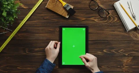 View from above on the black vertical tablet device on the wooden desk with Stock-Footage 96022009
