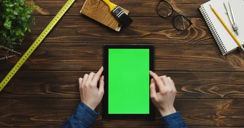 View from above on the black vertical tablet device on the wooden desk with Stock Footage 96023671