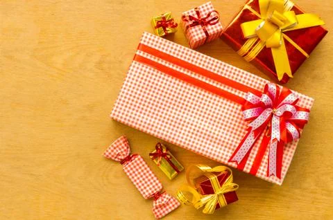 View above brown gift box and red ribbon with tag on wood background with spa Foto stock