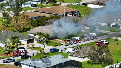 View from above of burning private house on fire and firefighters extinguishing Video stock 230585135