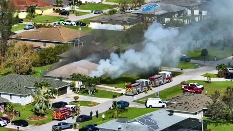 View from above of burning private house on fire and firefighters extinguishing Stock Footage 232971800