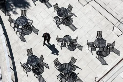 View from above of a businessman on his phone standing on a cafe terrace. Stock Photos