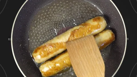 View from above. The chef fries two barbecue meat sausages in a hot skillet.  스톡 동영상 143377471