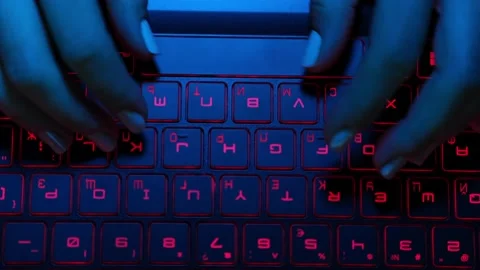 View from above. Close-up, fingers on the keyboard in blue light. Stock Footage 200102075