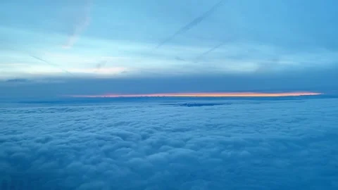 View Above Clouds From Airplane Window at Sunset Stock Footage 339992302