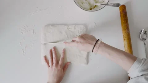 View from above. The cook cuts the puffed dough with a knife into several pieces Stock Footage 131161123